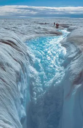 Photo showing meltwater at the top of the Greenland ice sheet flowing down a hole in the ice